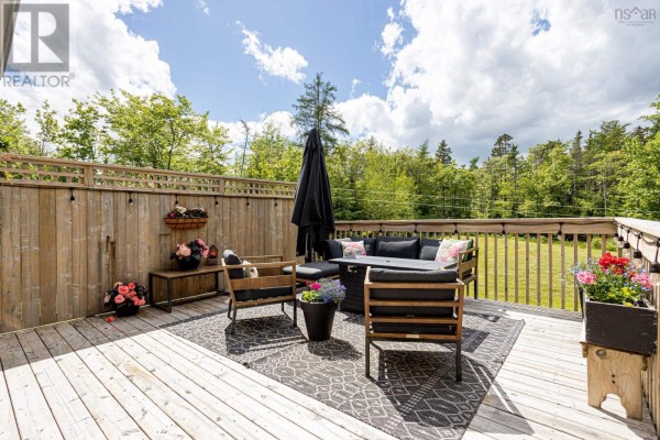 Wooden deck with outdoor furniture and potted flowers. - 71 Yezen Court, Hammonds Plains
