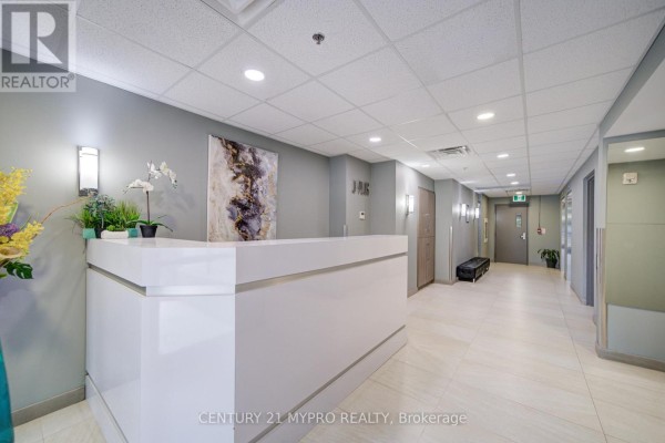 Building lobby features a white reception desk, artwork, and tiled floor. - 710 - 321 Spruce Street, Waterloo