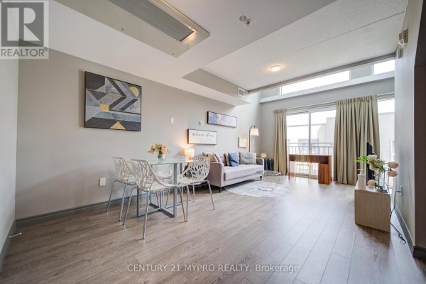 Living and dining area with grey walls, wood floor, and glass table. - 710 - 321 Spruce Street, Waterloo