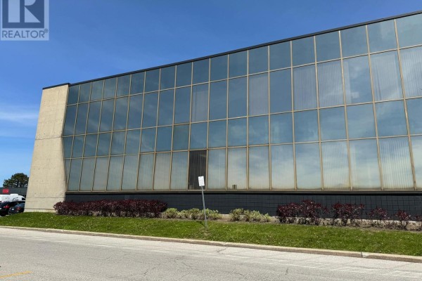 Exterior wall of 716 Gordon Baker Road building with reflective glass windows. - 710 - 716 Gordon Baker Road, Toronto