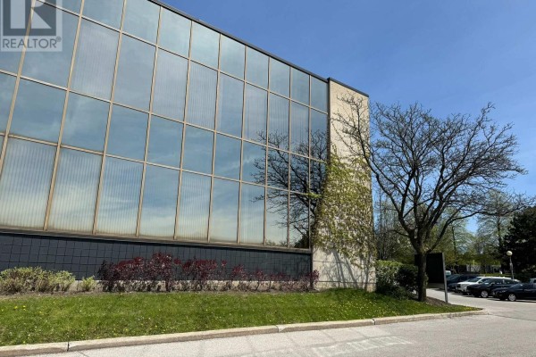 Close-up of the reflective glass exterior of 716 Gordon Baker Road building with ivy. - 710 - 716 Gordon Baker Road, Toronto