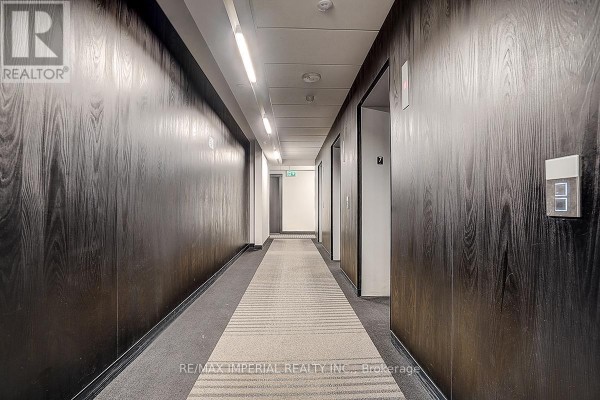Building entrance at 77 Shuter Street with glass doors and dark granite facade. - 710 - 77 Shuter Street, Toronto