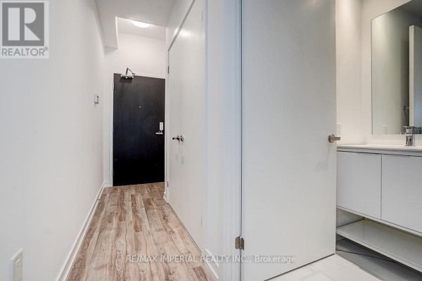 Apartment building lobby with white sofas, large square coffee table, and chandeliers. - 710 - 77 Shuter Street, Toronto