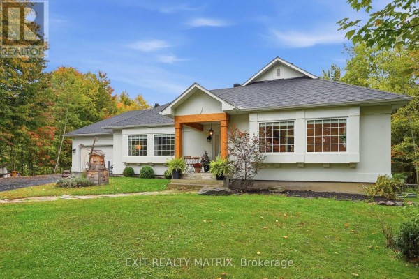 Close-up view of the white house entrance with wooden beams and large windows. - 710 Du Parc Road, Champlain