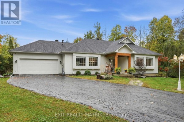 The driveway curves towards the white residential house with an attached garage. - 710 Du Parc Road, Champlain