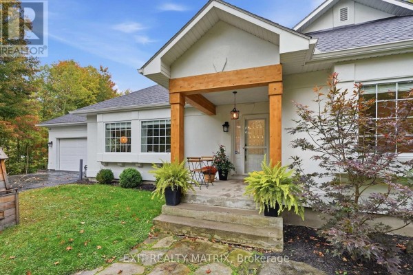 Front entrance with two stone steps, potted plants, and a small seating area. - 710 Du Parc Road, Champlain