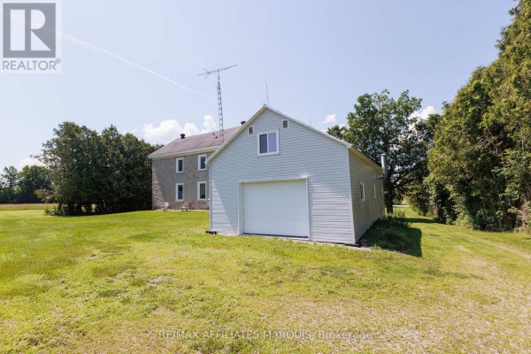 Aerial view of a farmstead including a house, barns, and surrounding fields. - 7105 Adams Road, Edwardsburgh/cardinal