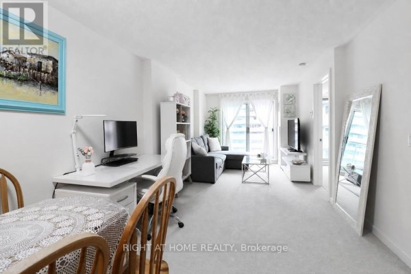 View of living room, desk area, and entryway from dining table. - 711 - 138 Somerset Street W, Ottawa
