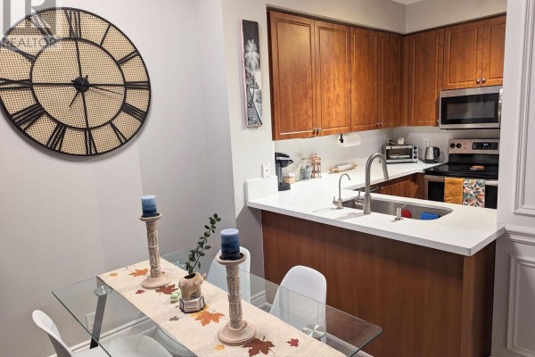 Close-up of kitchen sink, stainless steel dishwasher, and white quartz countertops. - 711 - 220 Burnhamthorpe Road W, Mississauga