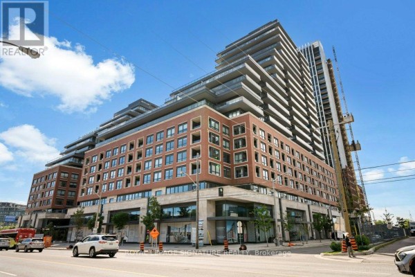 Exterior view of a large condominium building complex with multiple stepped sections and balconies. - 711 - 33 Frederick Todd Way, Toronto