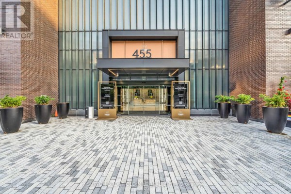 Entrance to a condo building with a paved walkway and planters. - 711 - 455 Wellington Street W, Toronto