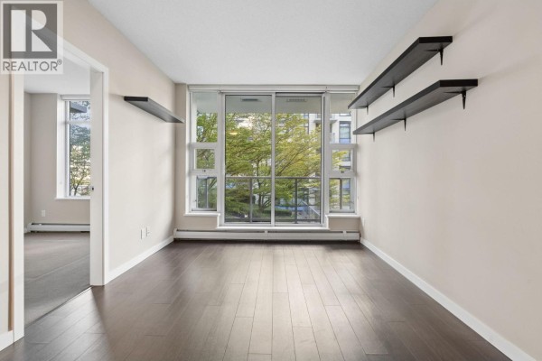 Living room with dark hardwood floors, beige walls, and a large window overlooking trees. - 711 1708 Columbia Street, Vancouver