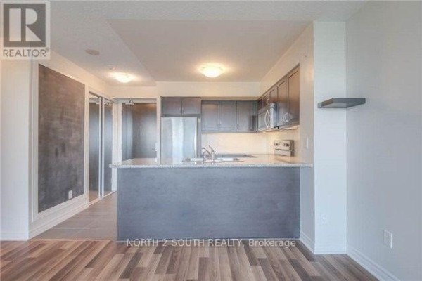 Open concept kitchen and living area with stainless steel appliances. - 712 - 25 Lower Simcoe Street, Toronto