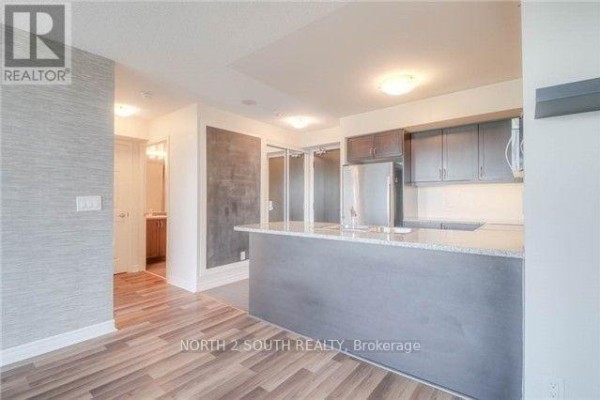 Living area and kitchen with view into hallway and bathroom. - 712 - 25 Lower Simcoe Street, Toronto