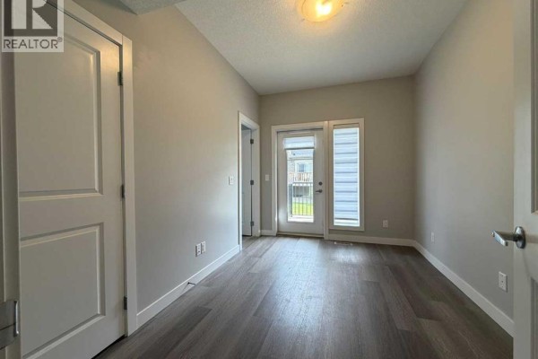 Bedroom with grey walls, white trim, and a double door leading to a balcony. - 712 Sage Hill Grove Nw, Calgary