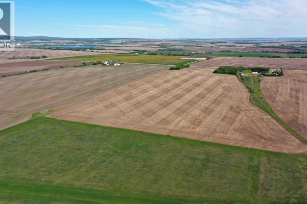 Expansive view of rural farmland with fields, trees, and a highway. - 712 Twp Road, Dimsdale