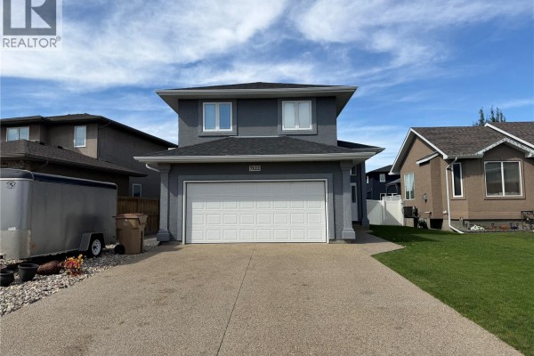 View of the house from the driveway, showing the garage door and front entrance. - 7122 Maple Vista Drive, Regina