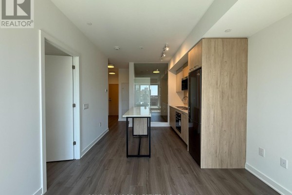 View of an open apartment layout from the entrance, featuring a kitchen, island, and hallway. - 714 - 30 Dreamers Way, Toronto