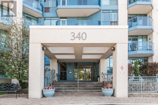 Entrance to the apartment building at 340 Watson Street West with stairs and planters. - 715 - 340 Watson Street W, Whitby