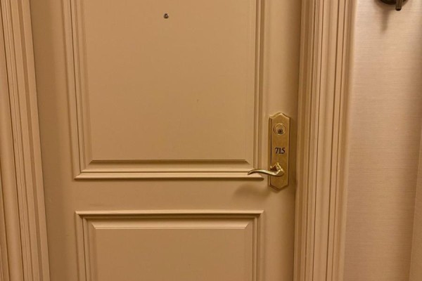 Close-up of a beige apartment door with a gold handle and a plaque reading '715'. - 715 - 9245 Jane Street, Vaughan