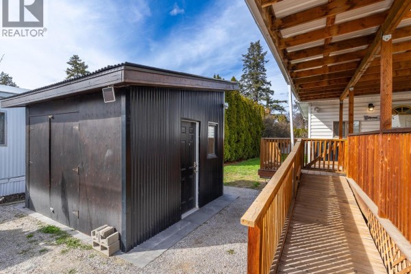 View of the wooden deck and ramp leading to the entrance of a mobile home. - 715 Beaver Lake Road Unit# 94, Kelowna