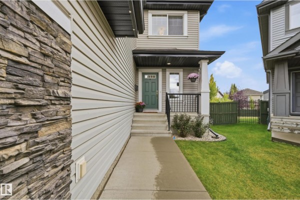 Exterior view of a house showing the front entrance with steps and walkway. - 715 Cache Pl, Sherwood Park