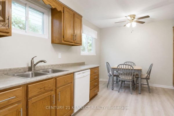 Kitchen with light wood cabinets, a double sink, white dishwasher, and a table with four chairs. - 715 Waverly Street N, Oshawa