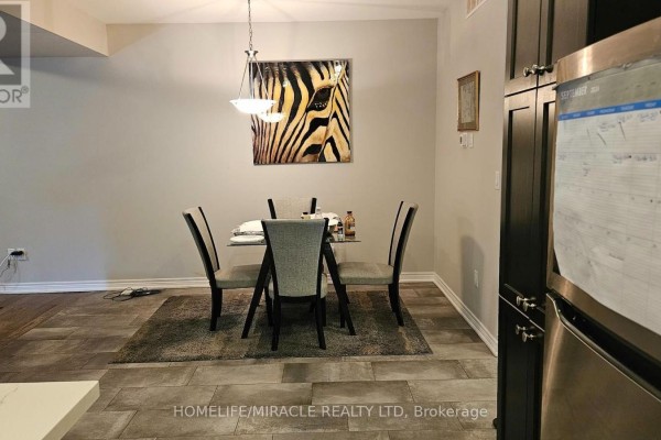 Dining area with a glass table, grey upholstered chairs, dark wood cabinets, and a zebra print artwork. - 7157 Parsa Street, Niagara Falls