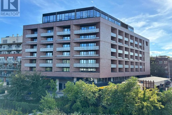 Exterior view of a modern brick apartment building with balconies and glass windows. - 716 - 383 Sorauren Avenue, Toronto