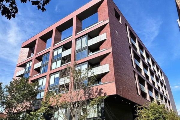 Low-angle view of a modern brick apartment building with balconies and glass windows. - 716 - 383 Sorauren Avenue, Toronto