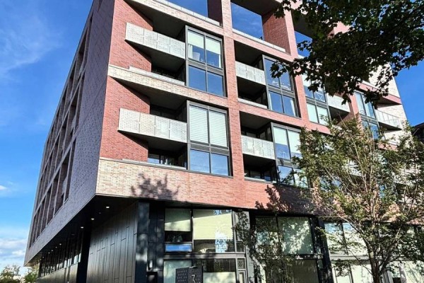 Close-up exterior view of a modern brick apartment building with balconies and glass windows. - 716 - 383 Sorauren Avenue, Toronto
