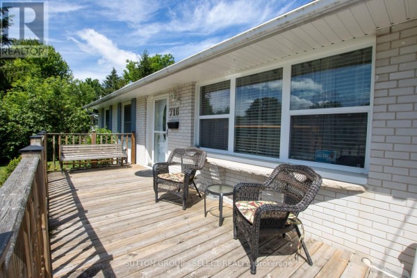 Wooden deck with two chairs and a side table in front of the house entrance. - 716 Monsarrat Avenue, London East
