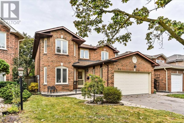 Front view of the house at 7164 Danton Promenade with landscaping and a paved walkway. - 7164 Danton Promenade, Mississauga
