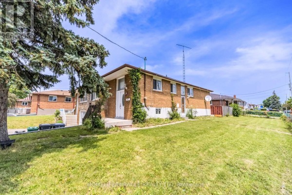 A brick house with large windows and a sloping lawn on a sunny day. - 7187 Darcel Avenue, Mississauga
