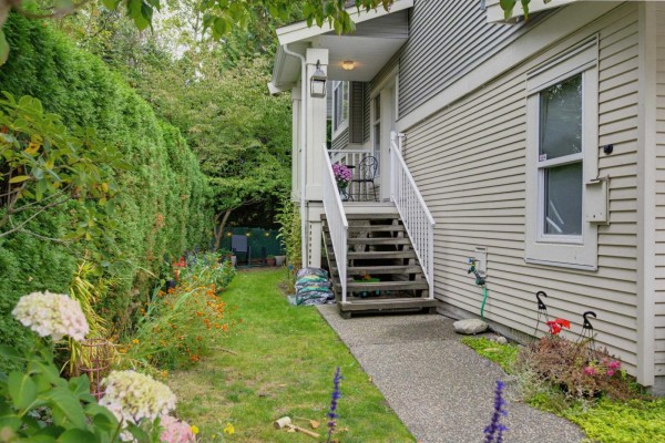 Side exterior of a grey townhouse with white stairs leading to the entrance. - 72 6450 199 Street, Langley