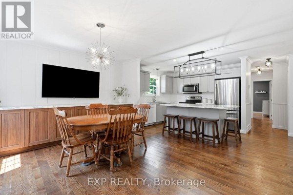 Open concept kitchen with island, dining set, and TV - 72 Crestlynn Crescent Norfolk