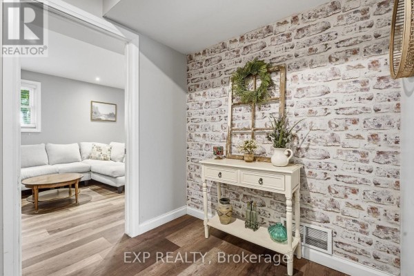 Distressed brick wallpaper hallway with console table and wreath - 72 Crestlynn Crescent Norfolk