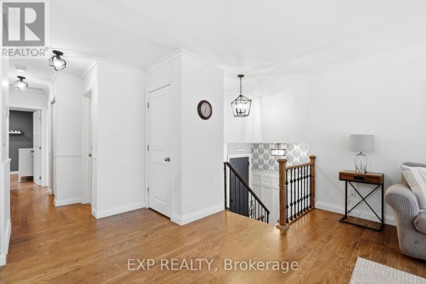 Interior view of the upper level hallway and living space with hardwood floors and white walls. - 72 Crestlynn Crescent, Norfolk