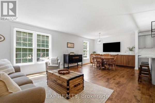 Living and dining area with sofa, trunk coffee table, dining set, TV, and kitchen island - 72 Crestlynn Crescent Norfolk