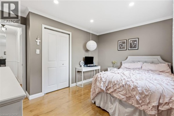 Bedroom with tufted headboard, ruffled bedding, and white desk - 72 Crestlynn Crescent Simcoe