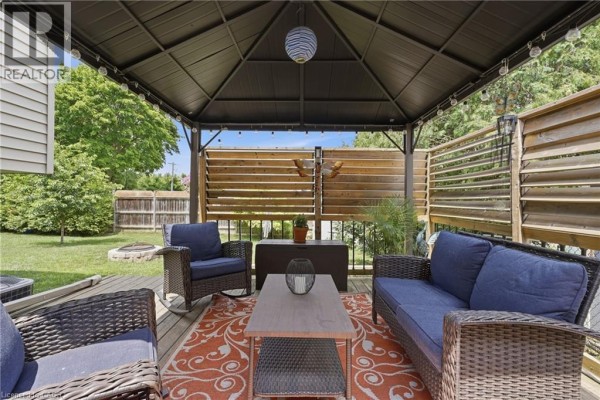 Covered patio with wicker sofa and chairs, fire pit - 72 Crestlynn Crescent Simcoe