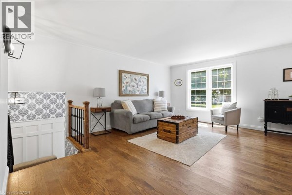 Living room with hardwood floors, gray sofa, and trunk coffee table - 72 Crestlynn Crescent Simcoe