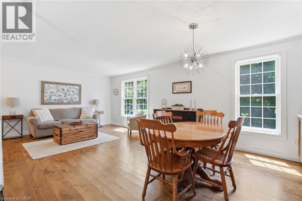 Living and dining room with sofa, coffee table trunk, and wooden dining set - 72 Crestlynn Crescent Simcoe