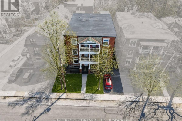Aerial view of a three-story red brick multi-family building with surrounding houses. - 72 Fifth Avenue, Ottawa