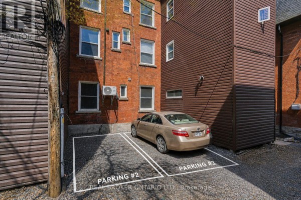 Gravel parking area marked Parking #2 and #3 with a car in Parking #2. - 72 Fifth Avenue, Ottawa