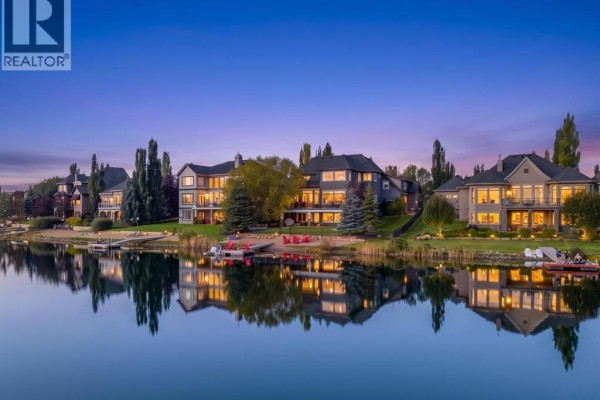 Aerial view of lakefront homes at sunset, reflected in the calm water. - 72 Heritage Lake Shores, Heritage Pointe