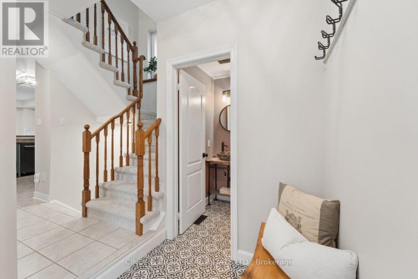 Interior entryway with light beige walls, a wooden bench, and patterned floor tiles. - 72 Lafayette Boulevard, Whitby