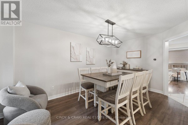 Open concept living and dining area with a stone fireplace and a view of the backyard. - 72 Lafayette Boulevard, Whitby