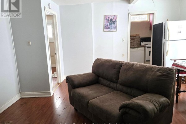 Cozy bedroom with a bed, clothing on shelves, and a small window - 72 Lebel Avenue, Kirkland Lake