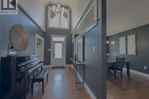 Interior view of a dark blue hallway with a piano and a glimpse of a dining room. - 72 Longwood Drive, Rothesay
